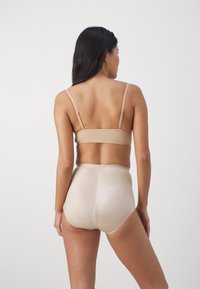 Light beige seamless bra and high-waisted underwear, made of smooth, stretchy material, featuring thin adjustable straps and a minimalist design.