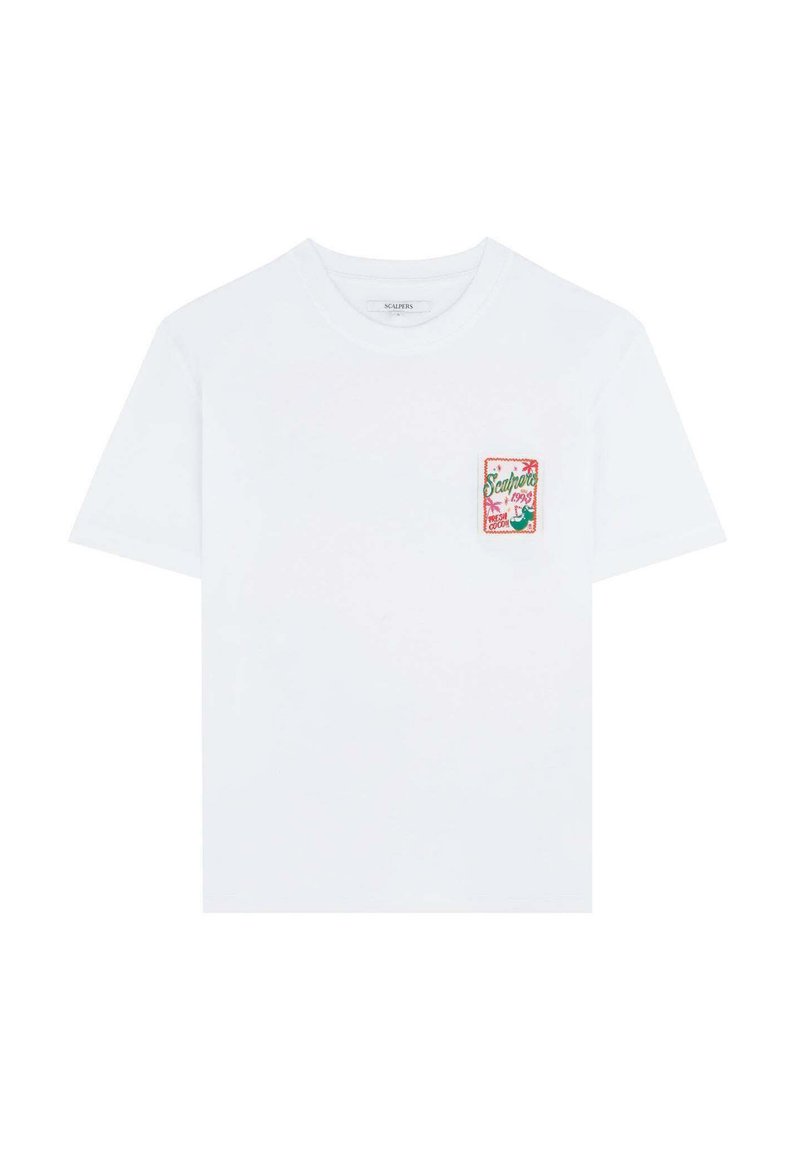 T-shirt en coton blanc à manches courtes, avec une pièce brodée colorée sur la poitrine gauche présentant des éléments de design tropical.