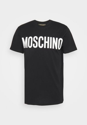 T-shirt en coton noir avec un grand logo "MOSCHINO" blanc sur le devant. Coupe col rond avec manches courtes, texture lisse.