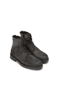 Botines de ante gris con punta redondeada, cordones en la parte delantera y superficie texturizada, que cuentan con una suela de goma contrastante y un sutil detalle de costura.