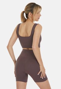 Geripptes Crop-Top und hoch taillierte Shorts in tiefem Mauve, aus dehnbarem Material, mit einer figurbetonten Passform und minimalistischem Ausschnitt.