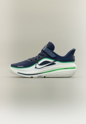 Granatowy but sportowy z białą podeszwą, zielonymi i białymi akcentami, siateczkową cholewką, paskiem na rzep i logo Nike swoosh z boku.