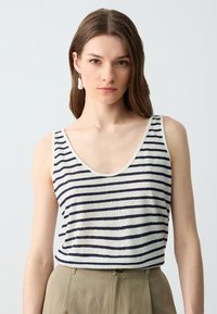 Gestreept tanktop in lichtbeige met navy horizontale strepen, ronde halslijn en dunne schouderbandjes, gecombineerd met beige hoge taille broeken.
