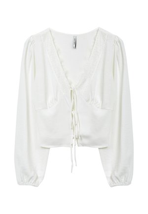 Blusa bianca con maniche lunghe a sbuffo; presenta un collo a V con bordatura in pizzo e chiusura a lacci nella parte anteriore. Tessuto morbido e leggero.