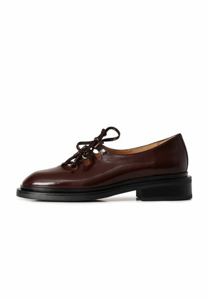 Bruine leren veterschoenen met een gladde afwerking, ronde neus en een lage zwarte hak. Voorzien van uitsnijdingen en decoratieve veters.