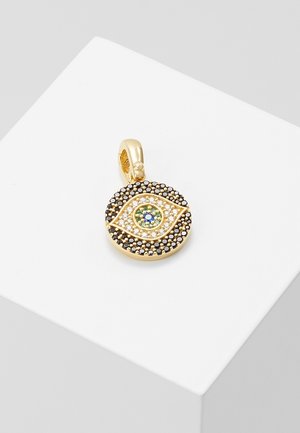 Pendentif en or en forme d'œil, décoré de petites pierres précieuses noires, blanches, vertes et bleues, présenté sur une surface blanche.