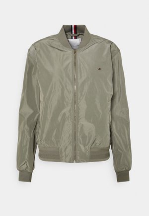 Veste bomber vert clair avec fermeture éclair sur le devant, poignets et ourlet côtelés, et petit logo sur la poitrine gauche.