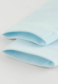 Tissu en coton bleu clair, texture lisse, bords pliés, couture propre, sans motifs ni détails de quincaillerie visibles.