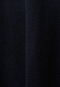Tissu tricoté bleu marine foncé avec un motif de points fin et régulier et un pli vertical subtil au centre.