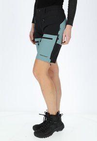 Pantaloni corti da escursionismo neri e teal con numerose tasche con cerniera, realizzati in tessuto resistente, dotati di vita elasticizzata e cuciture rinforzate.