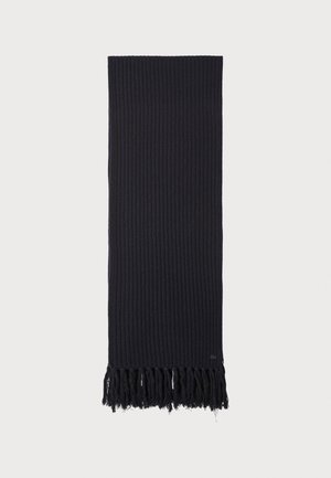 Navy knit scarf with ribbed texture and fringed edges. Features a small logo near the bottom. Rectangular shape.