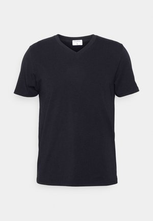 Camiseta negra de cuello en V hecha de algodón, con mangas cortas y un corte relajado. Diseño sencillo, sin patrones ni acentos adicionales.