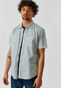 Kortärmige, knoopsluiting shirt van lichtblauwe stof met donkerblauwe geprinte accenten en een borstzak. Heeft een subtiel logo en een kraag.
