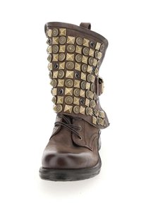 Brązowy botek za kostkę z teksturowaną skórzaną nawierzchnią oraz ozdobnymi ćwiekami. Posiada sznurówki, boczny klamrę i zaokrąglony nosek.