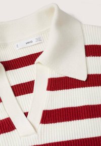 Polo en maille rayé rouge et blanc avec une texture côtelée, doté d'un col classique et d'une encolure en V. Étiquette visible près du col.