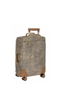 Valise à roulettes en tissu gris texturé avec des accents en cuir marron, une poignée rétractable et quatre roues pour une maniabilité optimale.