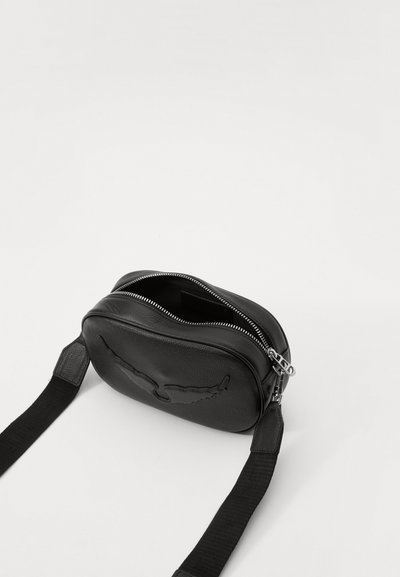 Černá kožená crossbody taška s texturovaným povrchem, zipovým uzávěrem a plochým popruhem. Má na přední straně embosovaný design křídel.