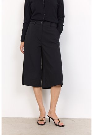 Black cropped wide-leg trousers with a high waist, featuring belt loops and front pockets, paired with black strappy high-heeled sandals.