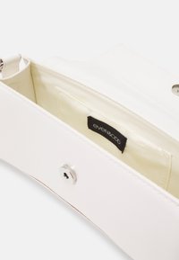 Borsa a mano sintetica bianca con una superficie liscia, dotata di una chiusura a scatto argentata e di una fodera beige con un'etichetta nera all'interno.