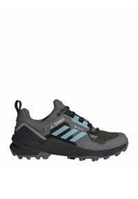 Grau Trail-Schuh mit schwarzen Akzenten, mit strukturiertem Obermaterial, Schnürverschluss und einem blauen Streifen. Entworfen für Outdoor-Aktivitäten mit einer robusten Sohle.
