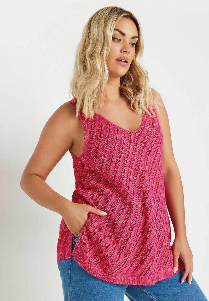 Rosa stickad linne med v-ringning, med ett vågmönster och en framficka. Materialet verkar lätt och något texturerat.