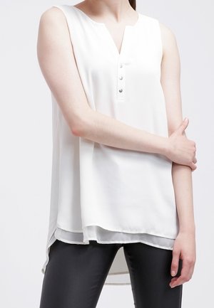 Top bianco senza maniche con scollatura a V e patta con cinque bottoni; tessuto leggero, orlo posteriore leggermente più lungo e una texture liscia.