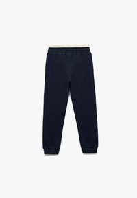 Pantalones de chándal azul marino con tejido texturizado, cinturilla elástica y puños. Con un suave forro interior de color crema.
