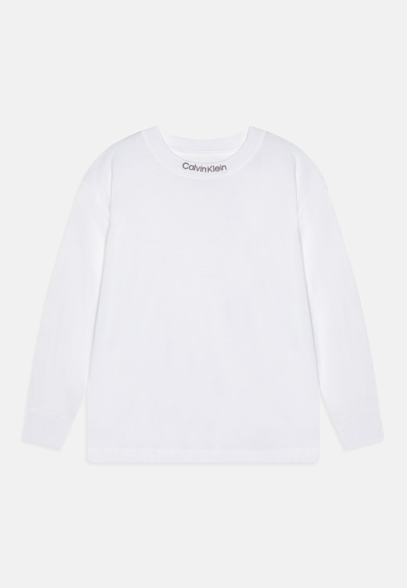 Bijela košulja dugih rukava napravljena od pamuka s okruglim izrezom. Sadrži "Calvin Klein" logo ispisan u sivoj boji na izrezu.