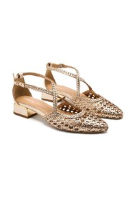 Zapatos slingback metálicos dorados tejidos con punta afilada, correas en el tobillo y un bajo tacón de bloque con un acento dorado.