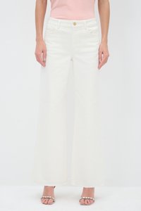 White wide-leg jeans made of denim feature a high waist, front pockets, and raw-edge hems. Paired with silver strappy sandals.