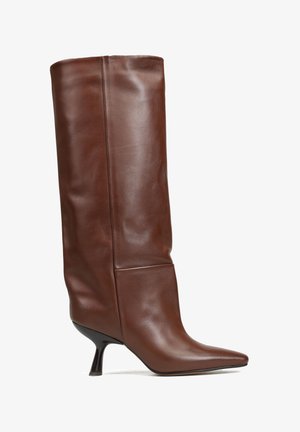 Brązowy skórzany półbut z wysokim cholewką, w szpic i na cienkim, czarnym obcasie. Projekt charakteryzuje się gładką teksturą i luźnym krojem.