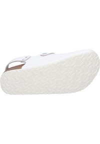 White slide sandal with a cork accent, featuring a textured rubber sole and a single adjustable strap with metal hardware.