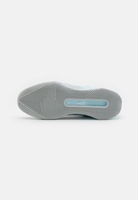 Semelle de chaussure de sport en caoutchouc gris clair. Présente un motif texturé et une section translucide bleue au centre.