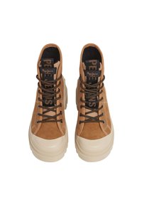 Bruine hoge schoenen met veters, met suède en rubberen zolen, vanbovenaf weergegeven tegen een witte achtergrond. Logo zichtbaar op de tong.