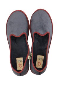 Zapatillas de tela gris con una textura suave, acentos rojos en los bordes y un diseño recortado en la parte superior. Etiquetas visibles en el interior.