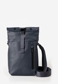 Dunkelgraue Roll-Top-Crossbody-Tasche mit vertikalem Reißverschlussfach auf der Vorderseite und verstellbarem Stoff-Schultergurt vor weißem Hintergrund.
