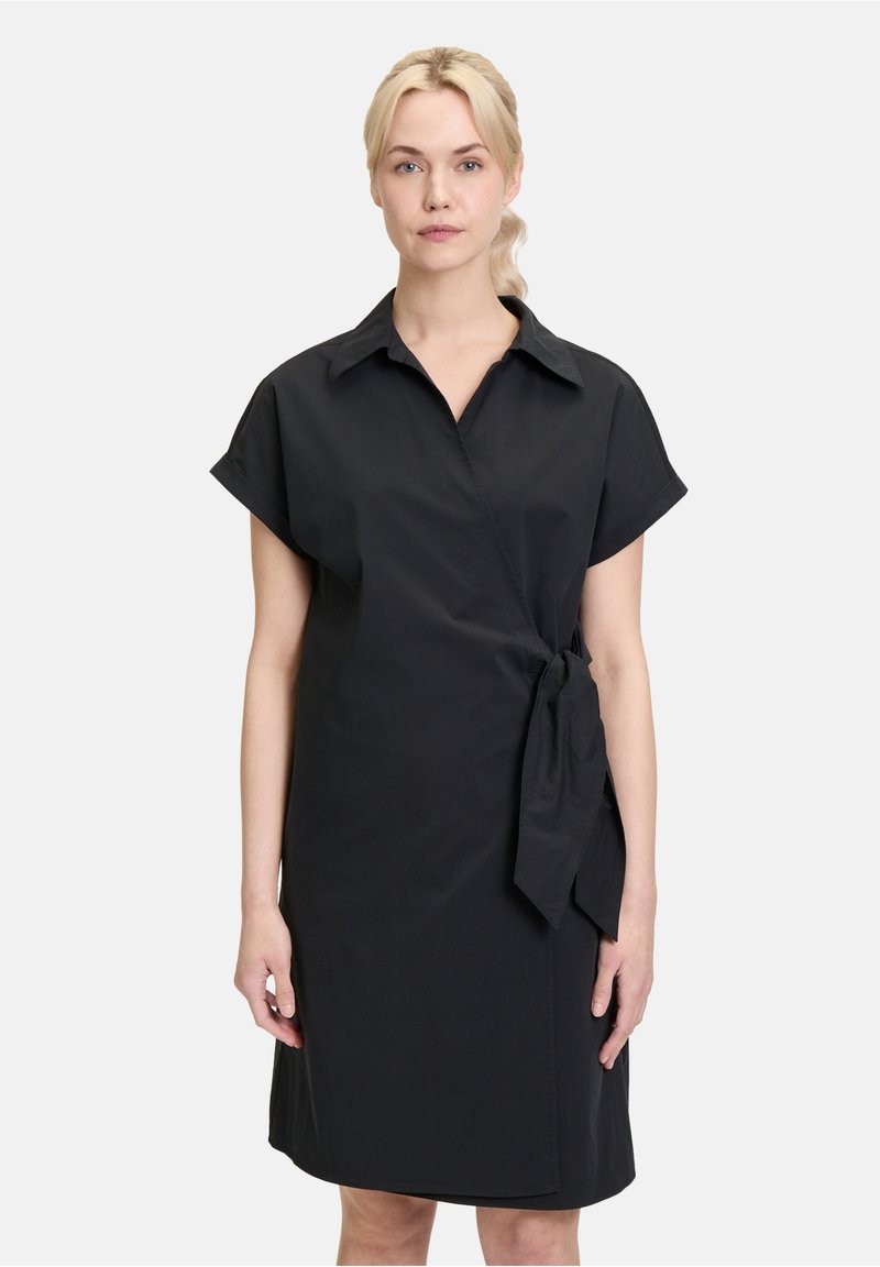 Schwarzes Wickelkleid mit kurzen Ärmeln, kragenförmigem Ausschnitt, seitlichem Bindegürtel und glatter Textur. Knielang mit einem einfachen, minimalistischen Design.