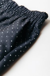 Temno mornarsko modra tkanina z nabranim pasom, okrašena z raztresenimi srebrnimi pikami. Mehka tekstura z zavesastim videzom.