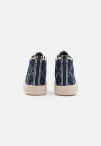 Hoge sneakers in marineblauw canvas met een gestructureerd ruitpatroon, beige rubberen zool en contrasterende stiksels langs de achterkant en zijkanten.
