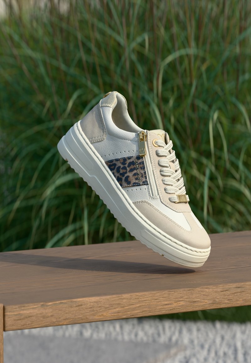 Baskets beige en cuir texturé avec panneau imprimé animal, dotées d'un accent de fermeture éclair dorée, d'une semelle blanche épaisse et d'un détail de fermeture à lacets.