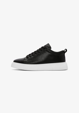 Sneaker in pelle nera con finitura liscia, suola in gomma bianca, punta rotonda e lacci con sette occhielli. Presenta un inserto sul tallone per una facile calzata.