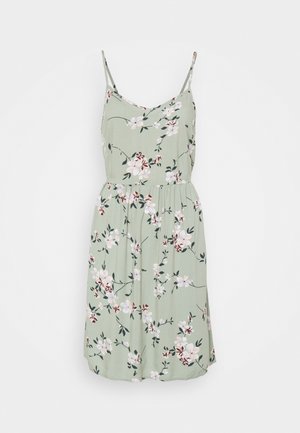 Robe florale en tissu vert clair avec des bretelles spaghetti, un décolleté en V et une taille froncée. Présente des motifs de fleurs blanches et bourgognes.