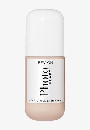Flacon de fond de teint Revlon PhotoReady Lift & Fill Skin Tint avec un bouchon blanc et un liquide beige visible à travers l'emballage transparent.