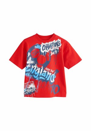 Red short-sleeve t-shirt with blue and white graffiti-style text including "England," "Champions," "Striker," and a soccer ball and goal graphic.