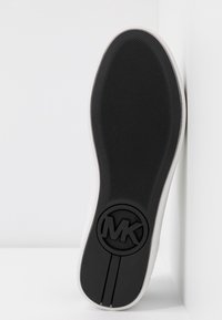 Semelle de basket blanche avec une semelle extérieure en caoutchouc noir texturé. Dispose d'un logo MK circulaire et d'un design simple et épuré.