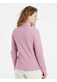 Pullover in pile rosa chiaro con colletto alto, maniche lunghe e una consistenza morbida. Presenta un design aderente, perfetto per essere indossato a strati.