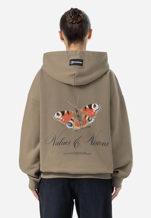 Felpa oversize marrone con una grafica di una farfalla sul retro. Presenta il testo "Valori & Visioni" in un font decorativo.