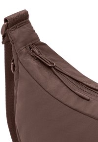 Borsa a tracolla in tessuto marrone con forma curvata, tasca esterna con zip e inserti testurizzati sulla tracolla per una maggiore presa e comfort.