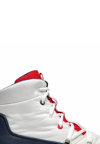 Zapatilla alta en blanco con acentos en rojo y marino. Parte superior de cuero suave, cordones planos y cuello acolchado para mayor comodidad.