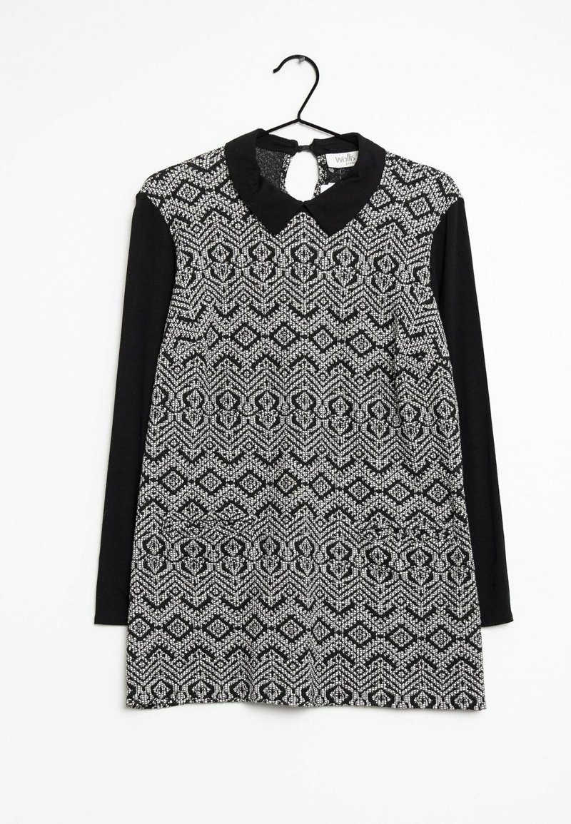 Svart och vit klänning med ett texturerat geometriskt mönster, korta ärmar och en krage. Slätt tyg med en definierad form och en nyckelhålsspärr på bak sidan.